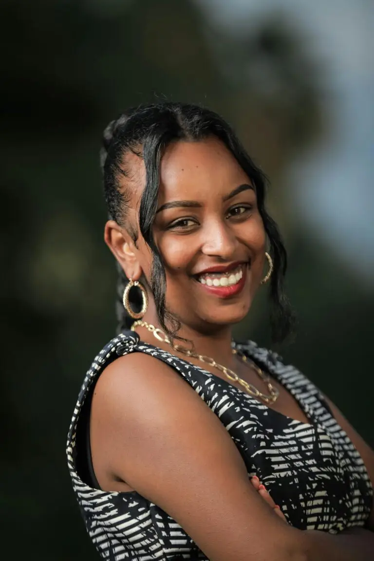 Portrait of a smiling woman outdoors with elegant jewelry in Oromia, Ethiopia.